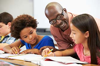 Teacher working with children on schoolwork.
